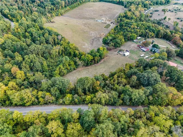 an aerial view of a residential houses with yard and green space