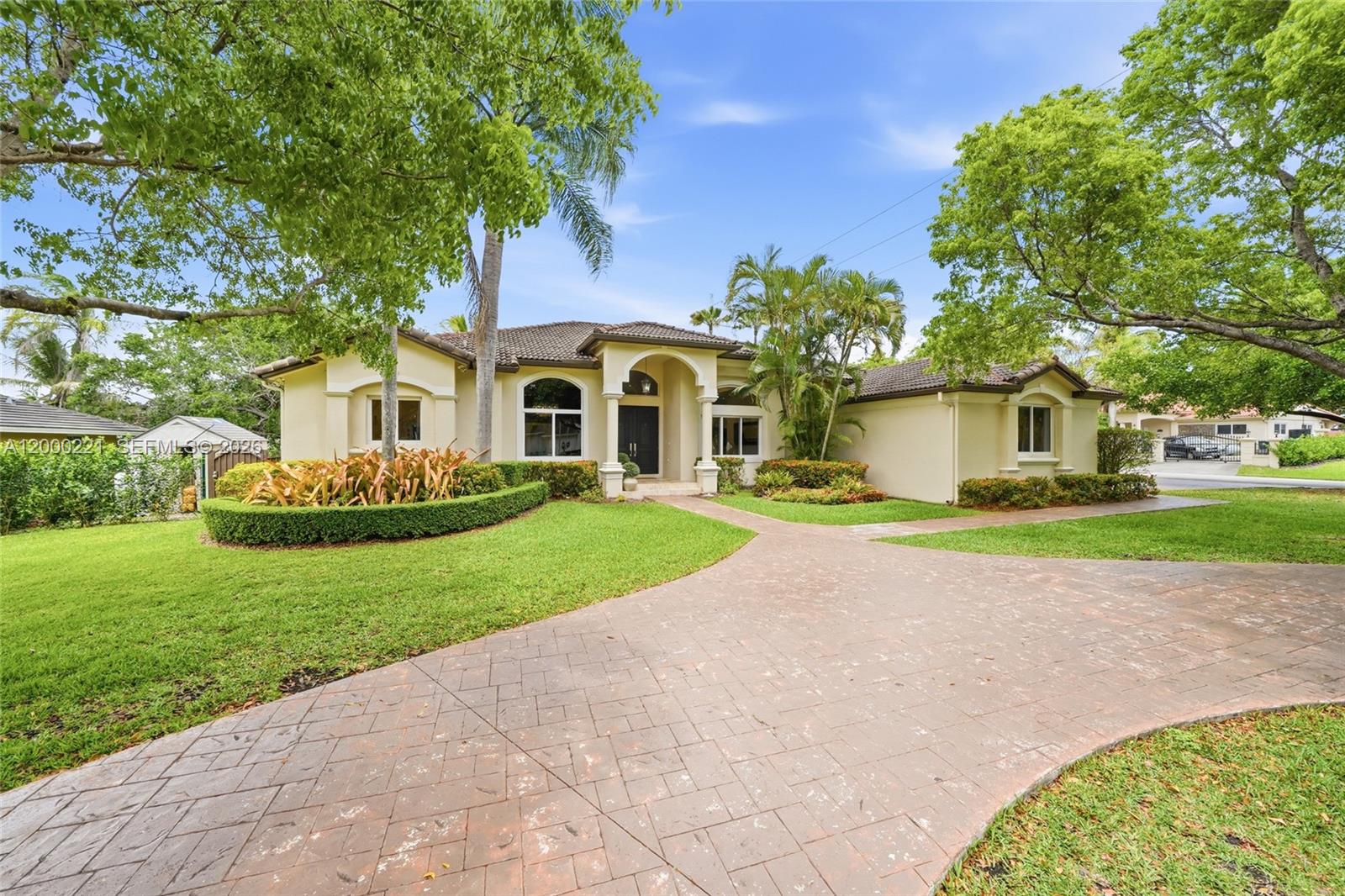 a front view of a house with a yard and trees