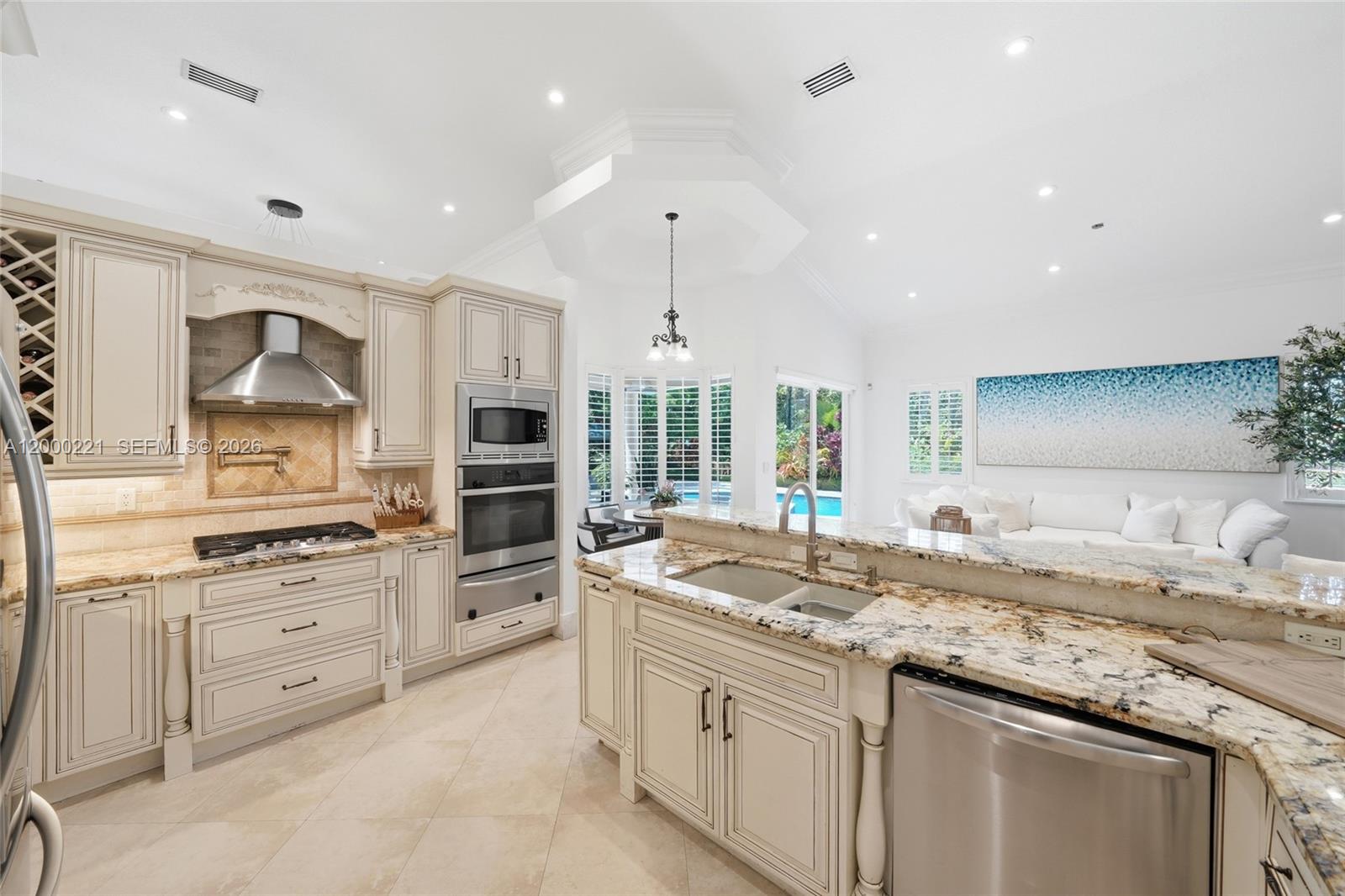 9901 Southwest 145th Street Miami, FL 33176 - Photo 14 of 78 a kitchen with granite countertop kitchen island white cabinets and stainless steel appliances