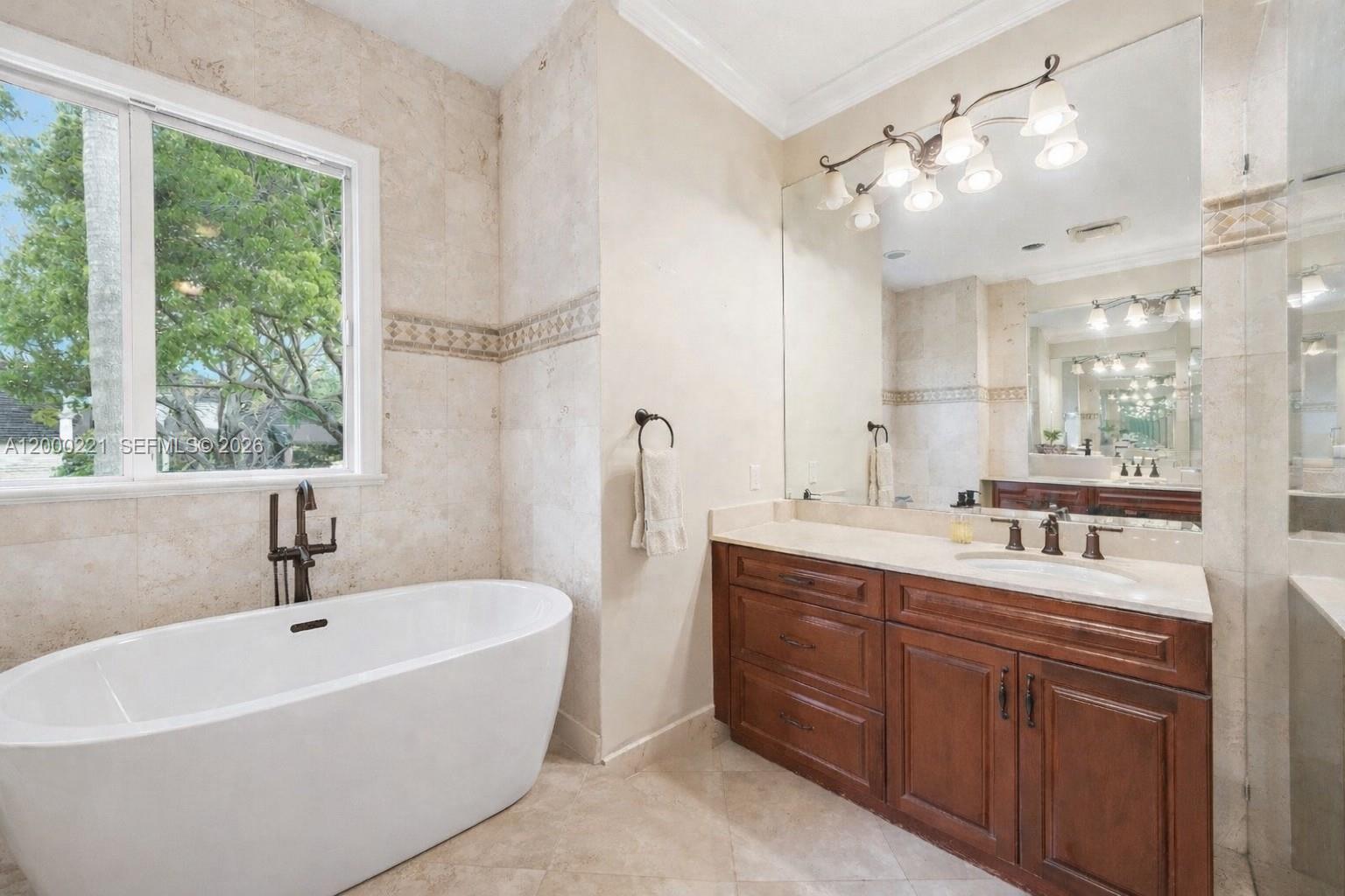 9901 Southwest 145th Street Miami, FL 33176 - Photo 29 of 78 a bathroom with a double vanity sink a mirror and a bathtub