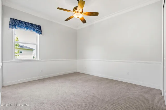 an empty room with a window and a ceiling fan