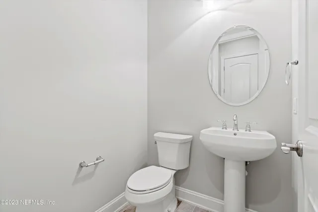 a bathroom with a sink a toilet and mirror