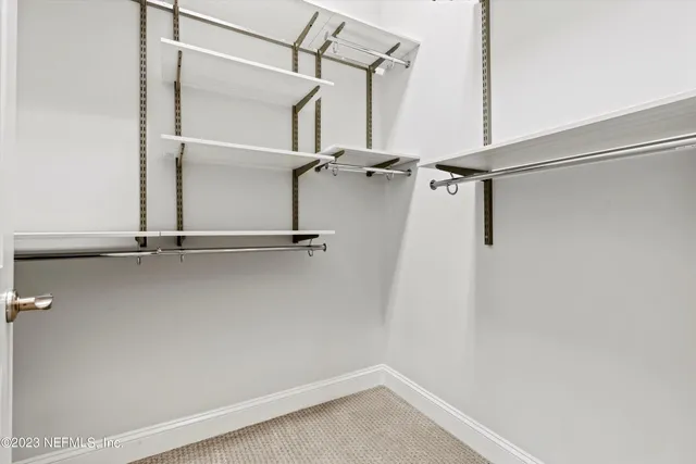 a view of walk in closet with empty racks