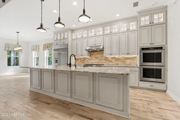a kitchen with kitchen island granite countertop a sink cabinets and stainless steel appliances