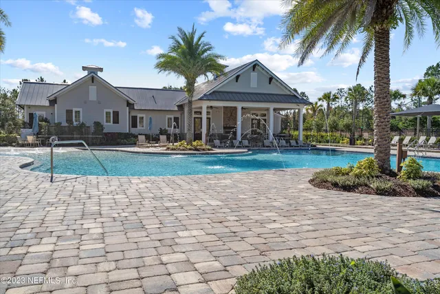 a view of a swimming pool with a lawn chair and palm trees