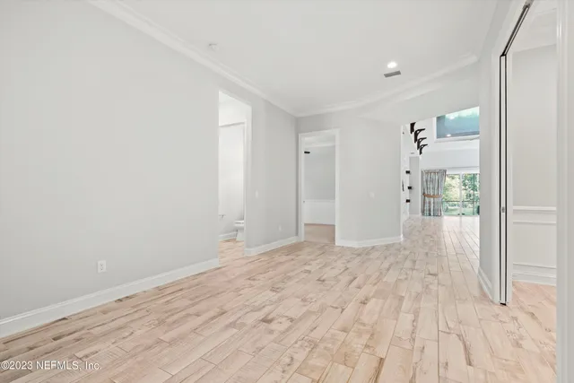 a view of a big room with wooden floor and windows