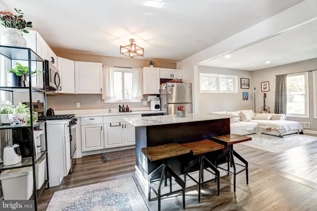 a living room with kitchen island furniture and a chandelier