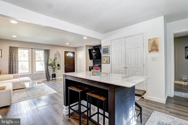 a living room with stainless steel appliances kitchen island granite countertop furniture and wooden floor