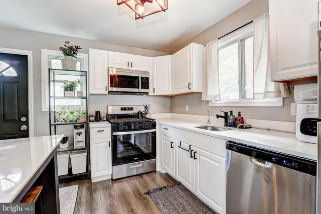 a kitchen with stainless steel appliances a stove sink microwave and cabinets