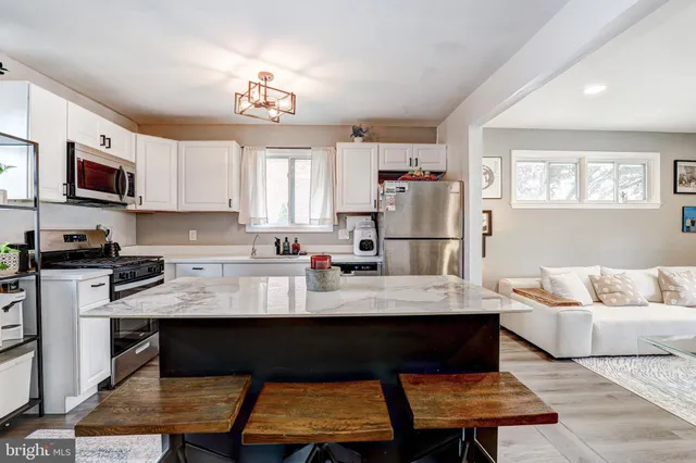 a kitchen with a refrigerator and a stove top oven