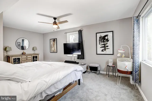 a bedroom with a bed window and a flat screen tv