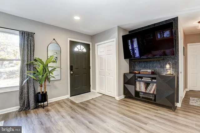 a living room with stainless steel appliances furniture and a flat screen tv