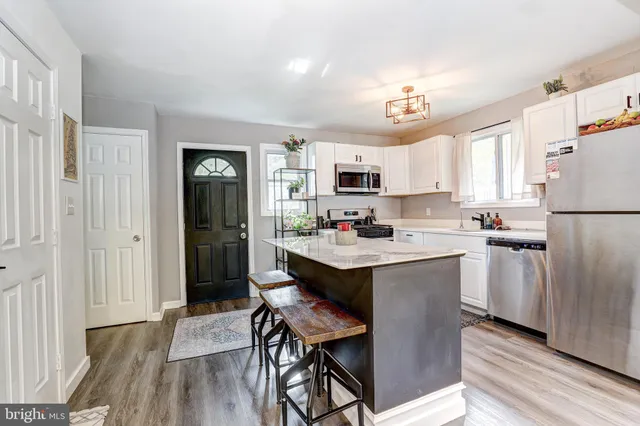 a kitchen with kitchen island a refrigerator a stove a sink dishwasher with a dining table and chairs