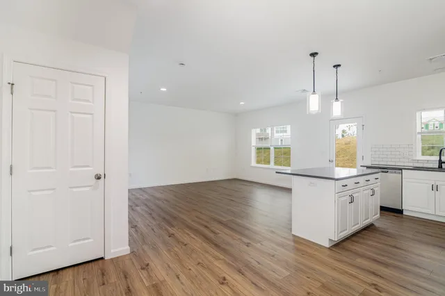 a kitchen with granite countertop a stove and wooden floor