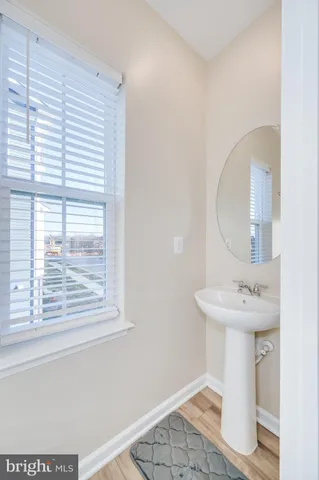 a kitchen with stainless steel appliances kitchen island granite countertop a refrigerator a stove a sink a dining table and chairs with wooden floor