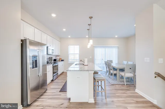 a kitchen with granite countertop cabinets a sink a window and stainless steel appliances