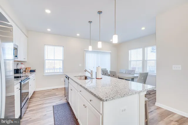 a kitchen with sink stove and living room
