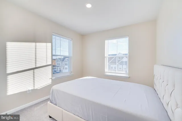a large bed sitting in a bedroom next to a window