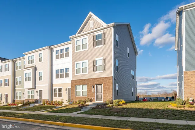 a front view of a building with lot of cars and trees