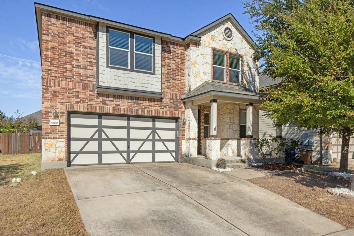 a front view of a house with a yard and a garage