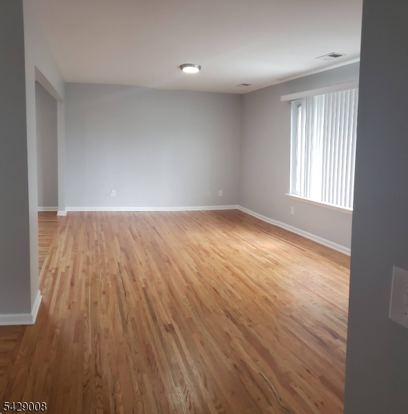 720 Walnut Street Linden, NJ 07036 - Photo 5 of 18 an empty room with wooden floor and windows
