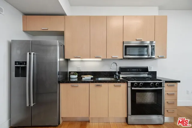 a kitchen with stainless steel appliances granite countertop a stove a refrigerator and a microwave