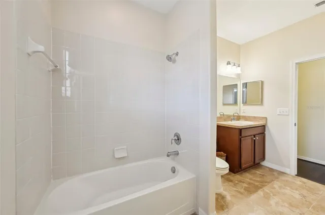 a bathroom with a tub sink and mirror