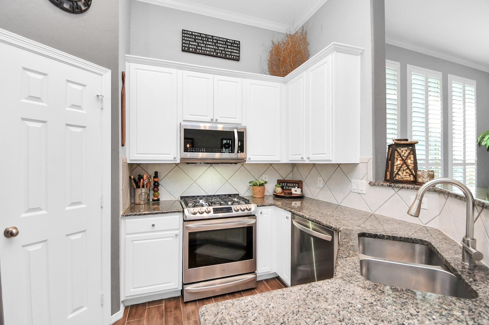 8624 Sunset Loch Drive Spring, TX 77379 - Photo 17 of 44 a kitchen with stainless steel appliances granite countertop a stove a sink and a microwave