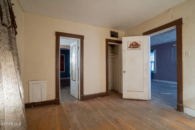 an empty room with wooden floor and closet