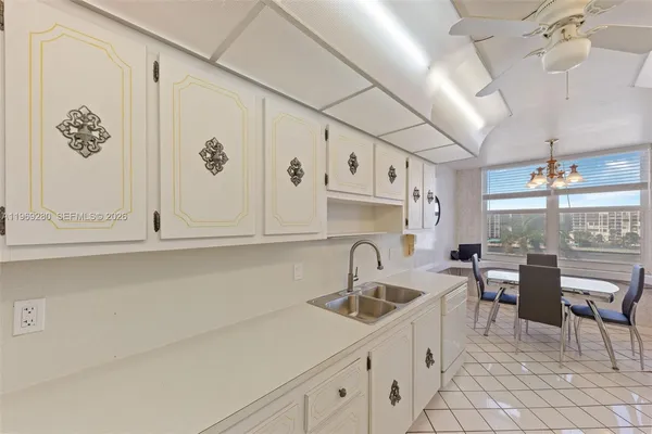 a kitchen with white cabinets and sink