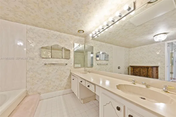 a spacious bathroom with a double vanity sink a mirror and a shower