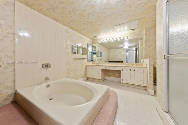 a spacious bathroom with a tub sink shower and mirror