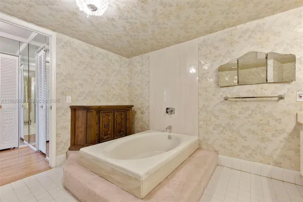 a bathroom with a white tub shower and sink