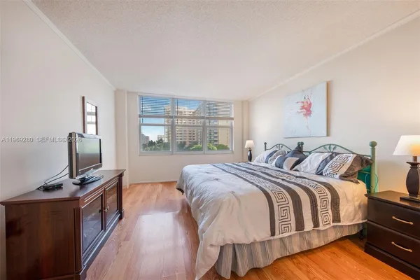 a bed room with a bed tv and a window