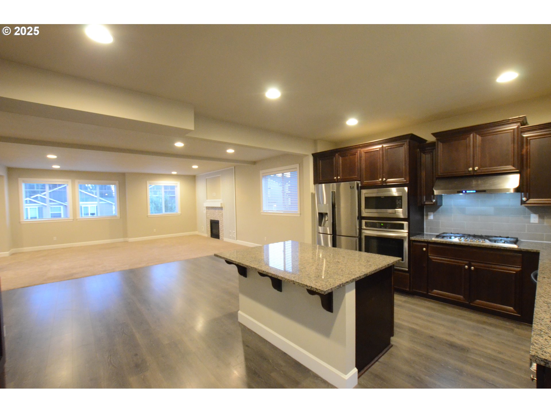 15557 Southwest Wren Lane Beaverton, OR 97007 - Photo 3 of 28 a large kitchen with stainless steel appliances a large counter top and a stove