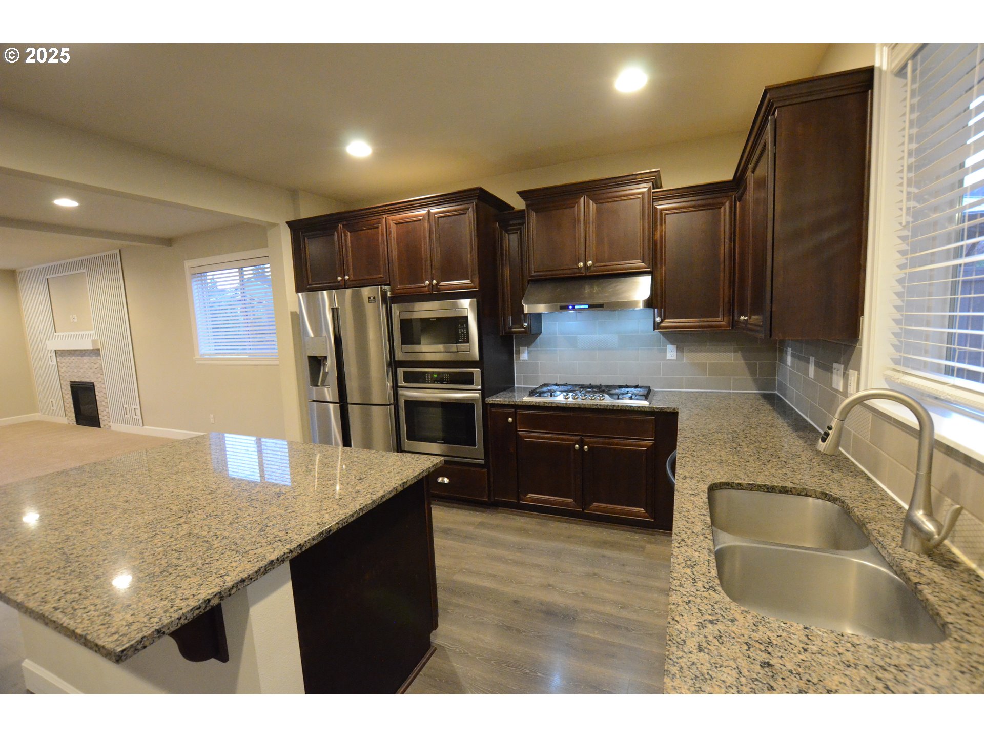 15557 Southwest Wren Lane Beaverton, OR 97007 - Photo 6 of 28 a kitchen with stainless steel appliances granite countertop a sink refrigerator and cabinets