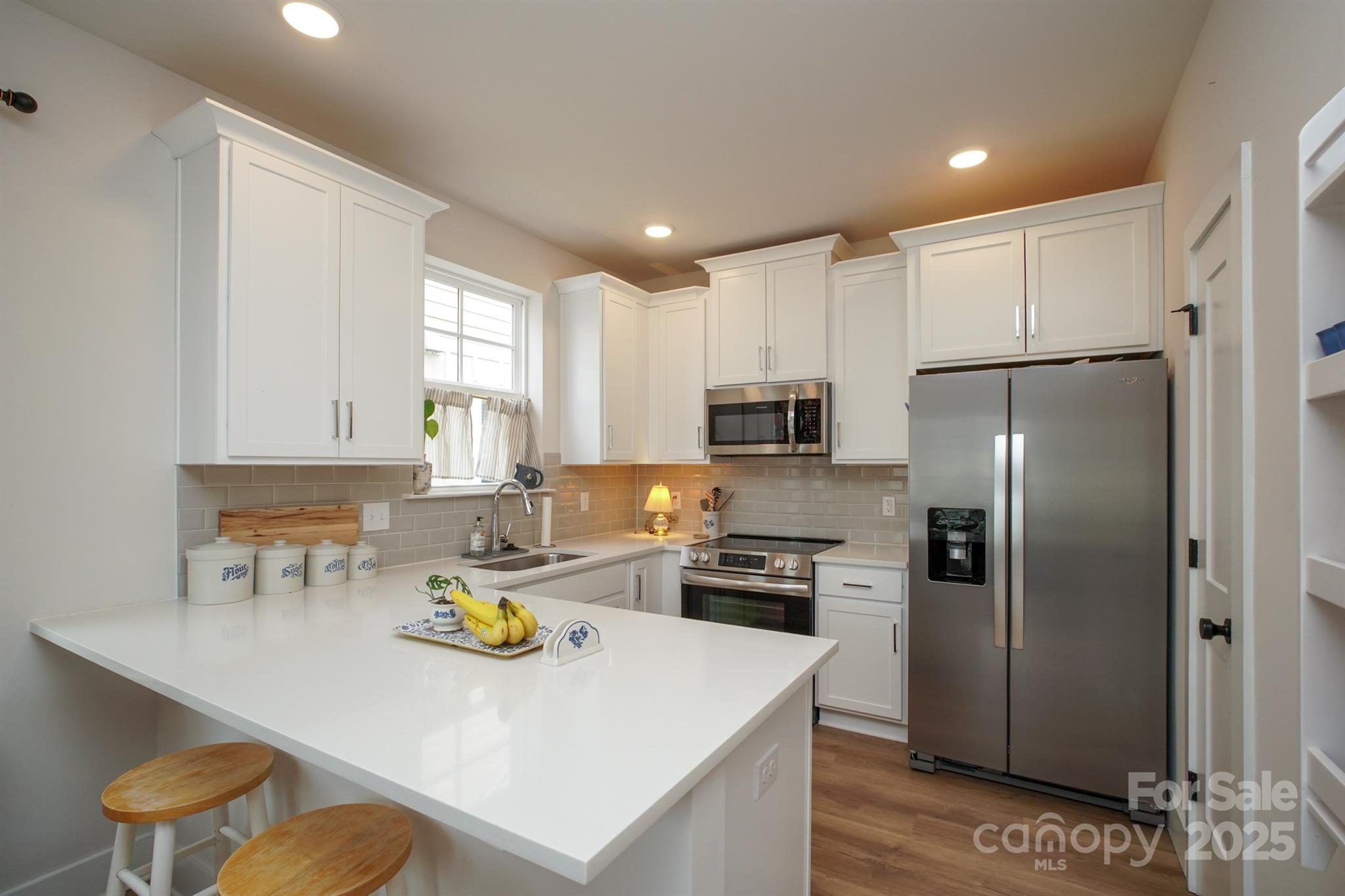 711 Beaty Street Davidson, NC 28036 - Photo 11 of 22 a kitchen with a refrigerator a stove a sink dishwasher with a dining table and chairs