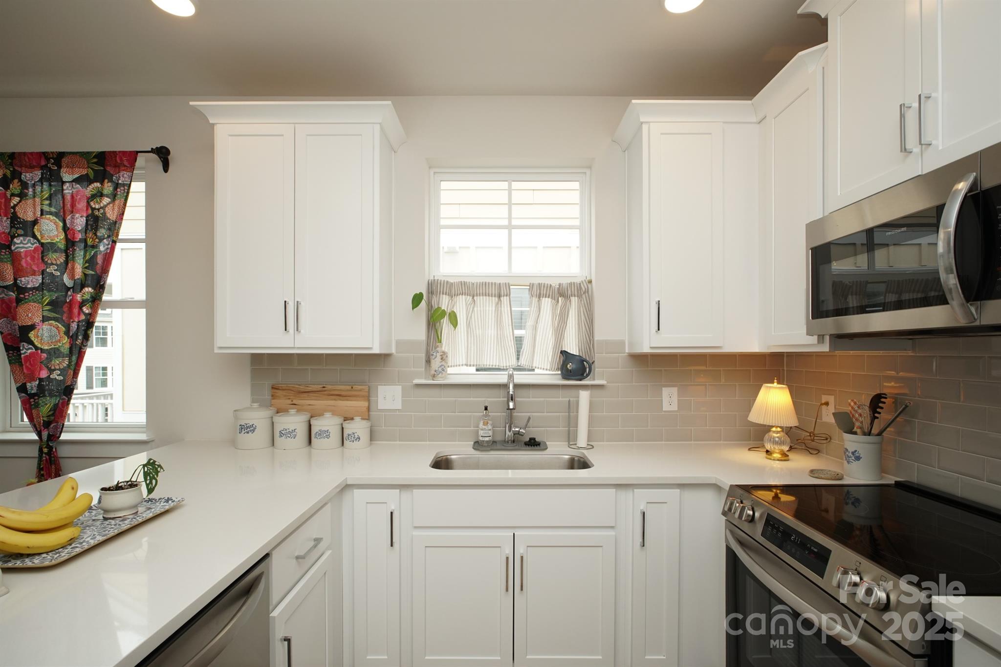 711 Beaty Street Davidson, NC 28036 - Photo 12 of 22 a kitchen with stainless steel appliances granite countertop a sink a stove a microwave cabinets and a window