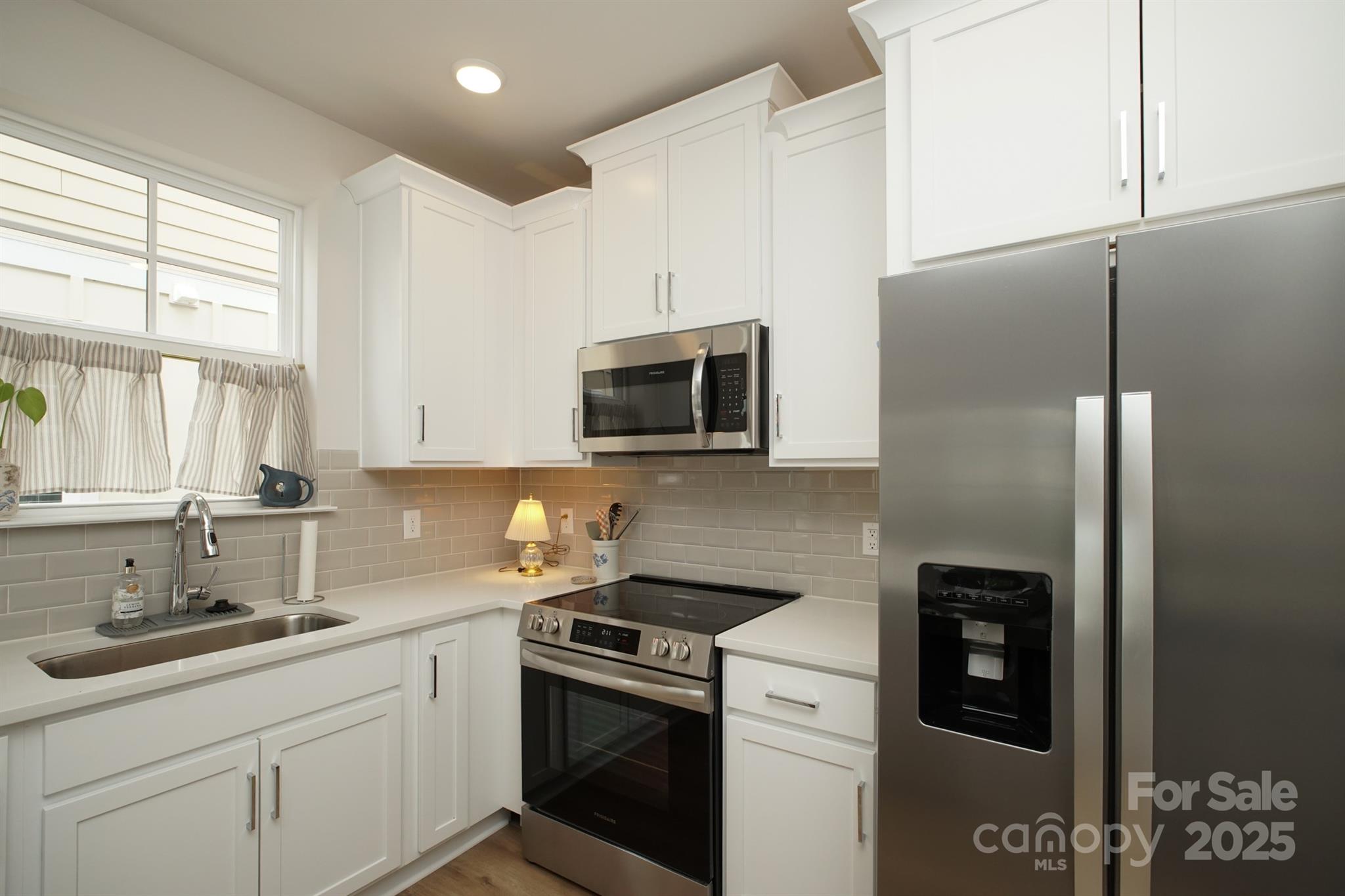 711 Beaty Street Davidson, NC 28036 - Photo 13 of 22 a kitchen with stainless steel appliances a refrigerator sink and microwave