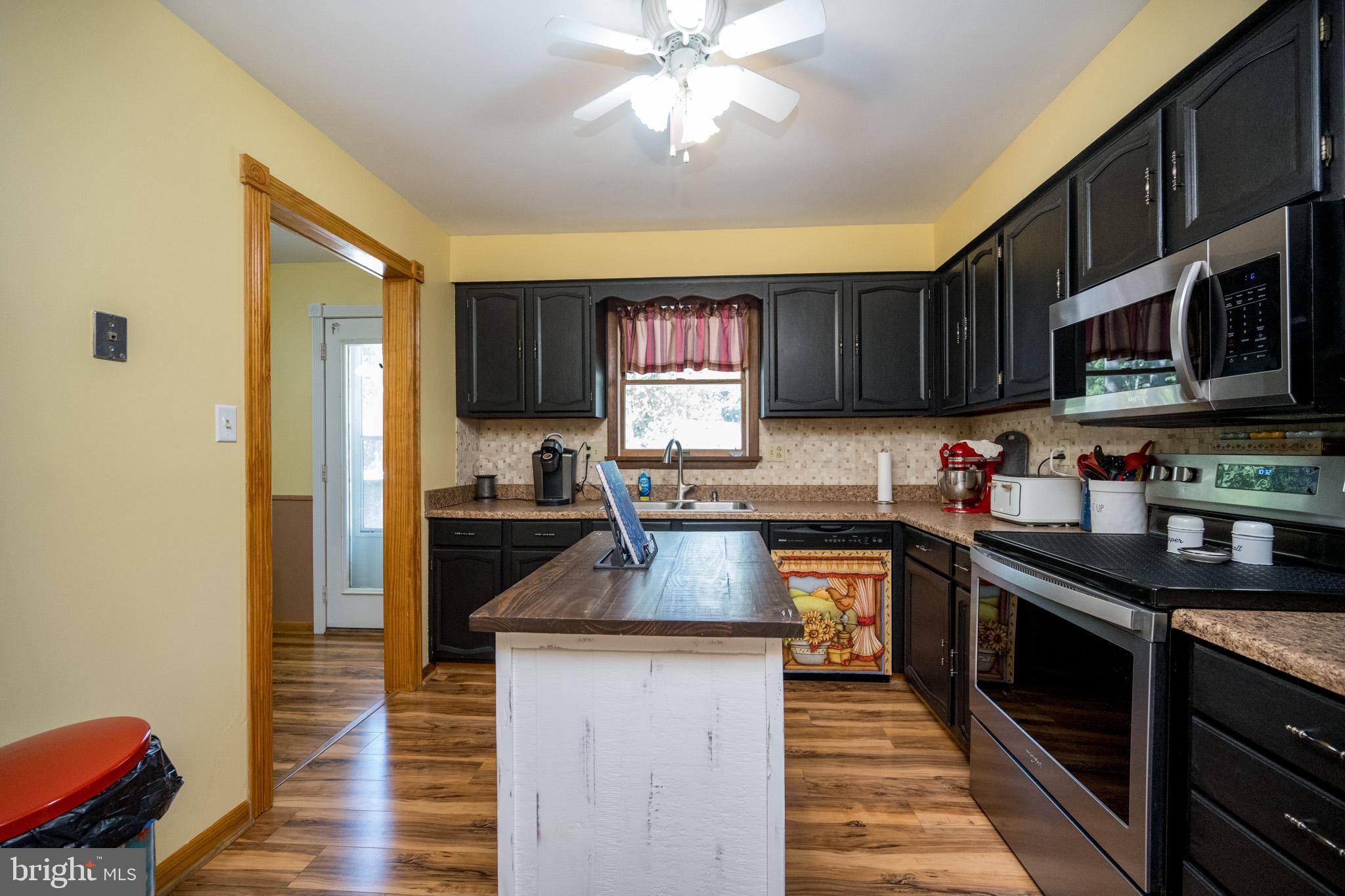 15105 Laurel Ridge Road Southwest Cumberland, MD 21502 - Photo 13 of 54 a kitchen with granite countertop wooden cabinets stainless steel appliances a sink and a window