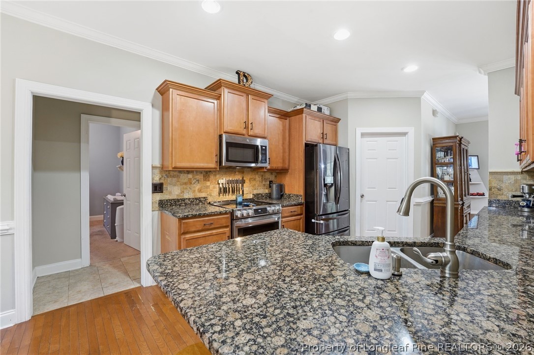 16 Ridge Road Jackson Springs, NC 27281 - Photo 22 of 50 a kitchen with stainless steel appliances granite countertop a refrigerator stove top oven a sink and dishwasher