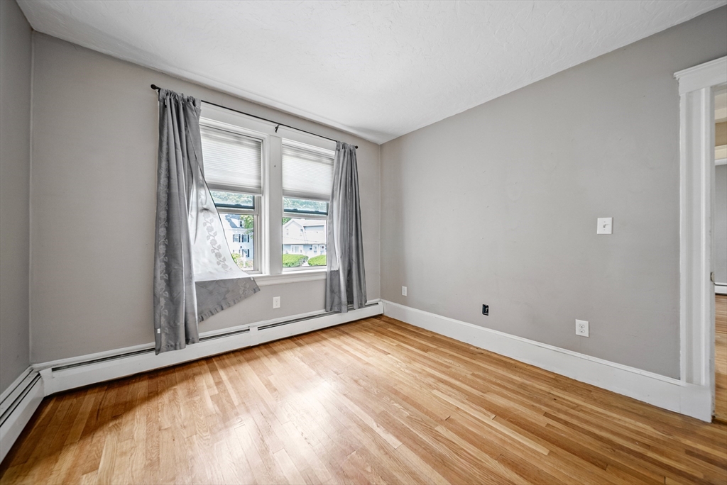 52 High Street, Unit 5 Methuen, MA 01844 - Photo 27 of 32 an empty room with wooden floor and windows
