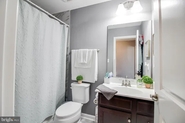 a bathroom with a sink vanity mirror and toilet