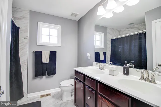 a bathroom with a double vanity sink toilet and shower