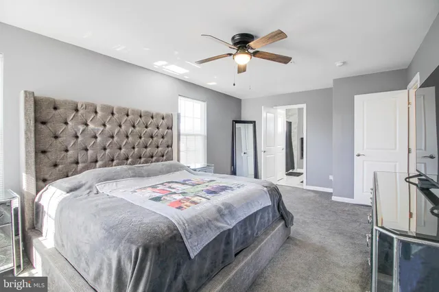 a spacious bedroom with a bed and a chandelier