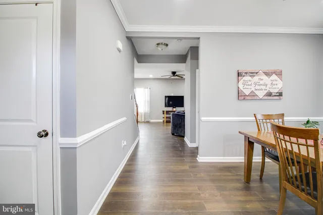 a view of a hallway with wooden floor and furniture