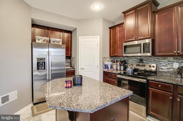 a kitchen with granite countertop stainless steel appliances and wooden cabinets