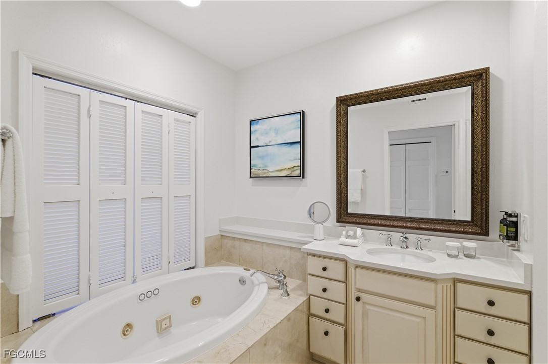 221 9th Street South, Unit 403 Naples, FL 34102 - Photo 14 of 31 a bathroom with a tub sink and mirror