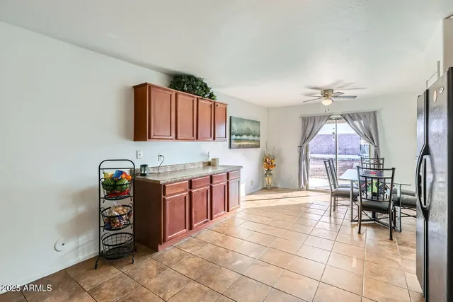 a kitchen with stainless steel appliances granite countertop a stove top oven a refrigerator a dining table and chairs with wooden floor