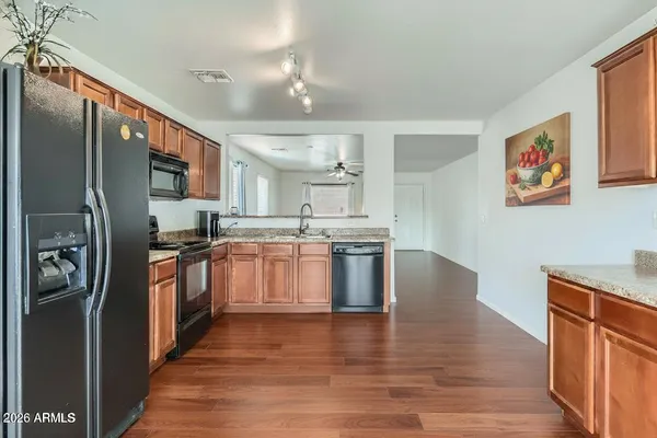 a kitchen with stainless steel appliances granite countertop a refrigerator a stove top oven a sink and dishwasher